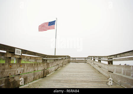 Flagge hoch Auf Beach Boardwalk Stockfoto