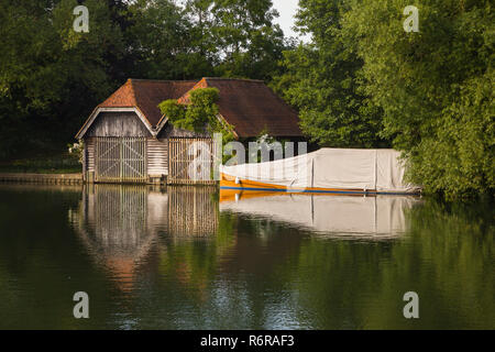 Ein altes Bootshaus und klassischen Mahagoni starten unter einer Plane auf der Themse bei Mill End, Buckinghamshire Stockfoto