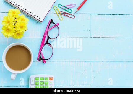 Ansicht von oben Büro Tisch mit Arbeitsbereich und Büro Zubehör einschließlich Rechner, Maus, Tastatur, Gläser, Clips, Blume, Kugelschreiber, Bleistift, Notenbuch und Laptop auf der Bright Green Holz- Hintergrund. Stockfoto
