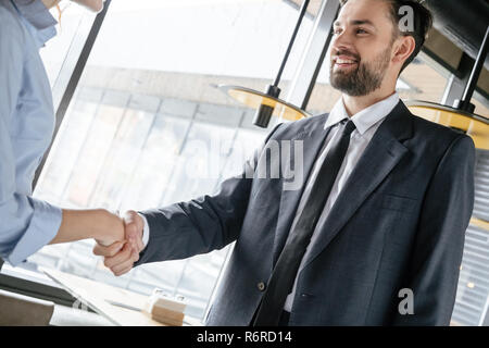 Geschäftsleute in Business Lunch im Restaurant stehend die Hände schütteln Stockfoto