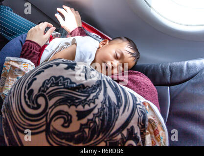 Kind Schlafen auf Schaufel während des Reisens auf Flugmodus Stockfoto