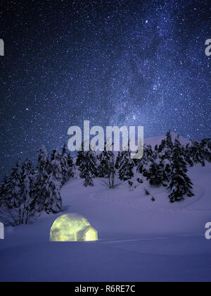 Nacht Wunderland im Winter. Iglu Schnee in der Tanne Wald unter einem Sternenhimmel. Tierheim in einem Berg Winterwanderung Stockfoto