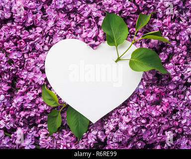 Happy Valentine's Day Karte mit einem leeren weißen Hinweis in Herz Form. Amors Pfeil von Grün leben. Schöne rosa Hintergrund von Blumen lila Stockfoto