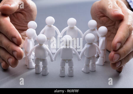 Die schützende Hand Miniatur menschliche Figuren Stockfoto