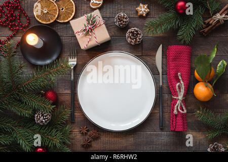 Authentische Weihnachten Tabelle einstellen. Leeren Teller, Kerzen, Besteck, Tannenbaum, Geschenkboxen. Ansicht von oben mit Platz für Text kopieren Stockfoto