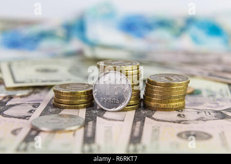 Ein Rubel vor dem Hintergrund der gestapelte Münzen 10 Rubel liegen auf dollarscheine Stockfoto