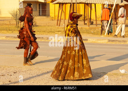 Ein Himba und Herero womans in vollem Ornat zu Fuß auf den Straßen von Opuwo, Namibia Stockfoto