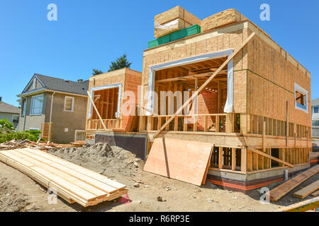 Neue Familie Haus im Bau mit Stapeln von 2 x 4 Holz Bretter auf der Oberseite Stockfoto