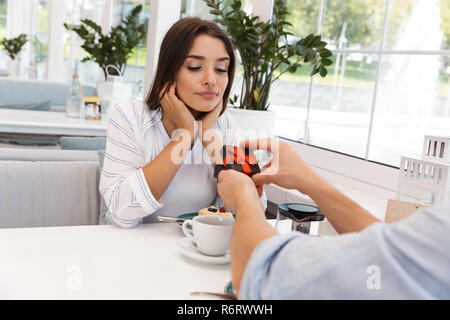 Bild von erstaunlichen jungen Liebespaar im Cafe sitzen. Mann gibt, ein Geschenk zu seiner Freundin. Stockfoto