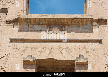 Hieroglypic Schnitzereien an der Wand am Eingang zum alten ägyptischen Tempel des Horus von Edfu Stockfoto