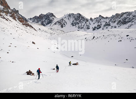 Drei Touristen auf dem Schnee trail klettern die Berge Stockfoto