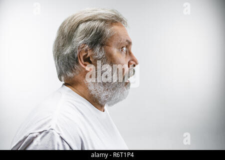 Der ältere attraktiver Mann schaut überrascht auf Weiß isoliert Stockfoto