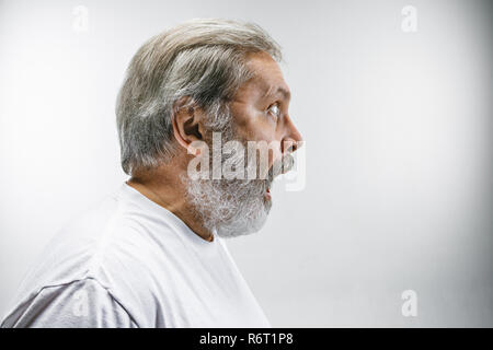 Der ältere attraktiver Mann schaut überrascht auf Weiß isoliert Stockfoto