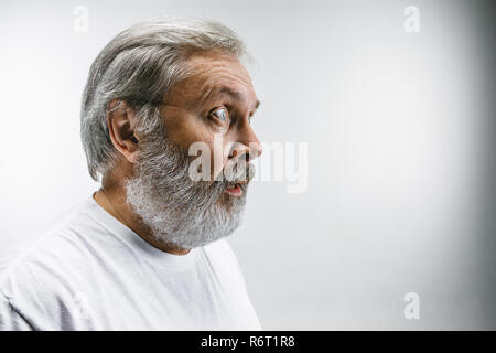 Der ältere attraktiver Mann schaut überrascht auf Weiß isoliert Stockfoto