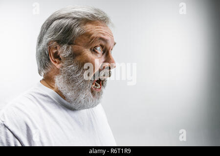 Die älteren emotionalen wütenden Mann schreiend auf weißem Studiohintergrund Stockfoto