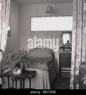 1960, historische, eine alte Perons' Bett und die umliegenden Möbeln in einem Pflege- oder Pflegeheim der Ära. Stockfoto