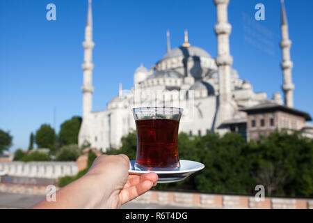 Frau mit Tasse traditionellen türkischen Kaffee auf der Terrasse mit Blick auf die Blaue Moschee in Istanbul in der Türkei. Stockfoto