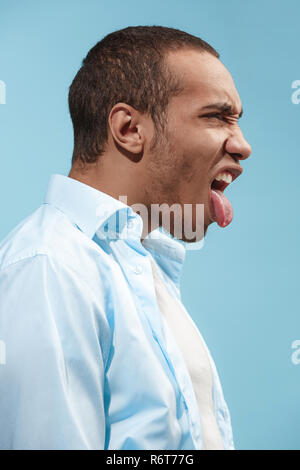 Crazy afro-amerikanischer Mann ist auf der Suche lustig vor blauem Hintergrund Stockfoto