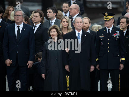 Ehemalige Pres George W. Bush und seiner Frau Laura und anderen Mitgliedern der Familie stand auf der Aufmerksamkeit als militärische Ehrengarde trägt die Schatulle von Bushs Vater, ehemaliger Präsident George H.W. Bush, zu einem leichenwagen vor der Beerdigung in der Nähe des George Bush Bibliothek Stockfoto