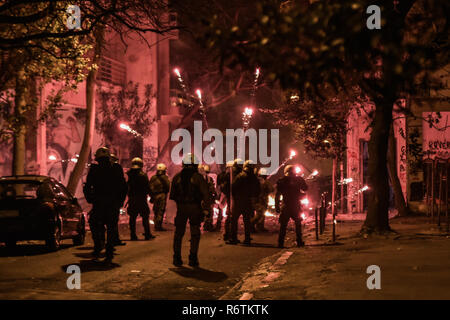 Ein Feuerwerk explodierte als Polizisten Zusammentreffen mit Demonstranten auf einer Kundgebung anlässlich des 10. Jahrestages der Ermordung von Teenager Alexis Grigoropoulos durch eine Griechische Polizisten in Athen. Stockfoto