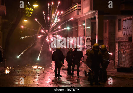 Ein Feuerwerk explodierte als Polizisten Zusammentreffen mit Demonstranten auf einer Kundgebung anlässlich des 10. Jahrestages der Ermordung von Teenager Alexis Grigoropoulos durch eine Griechische Polizisten in Athen. Stockfoto