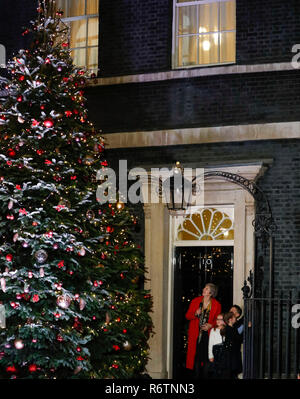 London, Großbritannien. 6 Dez, 2018. Der britische Premierminister Theresa können Switches auf der Weihnachtsbaumbeleuchtungen außerhalb Downing Street 10 mit drei Kindern in London, Großbritannien am Dez. 6, 2018. Credit: Han Yan/Xinhua/Alamy leben Nachrichten Stockfoto