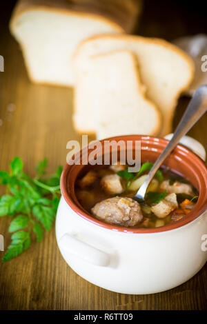 Gemüsesuppe mit Bohnen und Hackfleischbällchen in eine keramische Schüssel Stockfoto