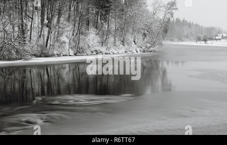 Panorama Winterlandschaft mit Linie der Bäume im Wasser widerspiegelt. Neue Jahre Hintergrund. Schwarz-weiß-Fotografie. Stockfoto