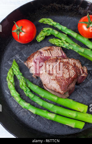 Rindersteak und grünem Spargel in einem Topf Stockfoto