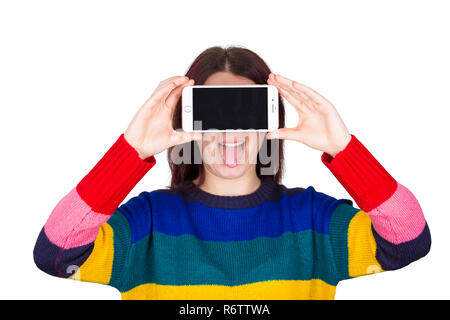 Lustige junge Frau mit der Zunge halten Handy in der Nähe von Augen, Gesicht auf weißem Hintergrund. Stockfoto