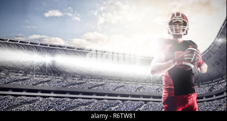 American Football Spieler mit Helm Vorbereitung Kugel gegen das zusammengesetzte Bild von arena Sport gegen bewölkter Himmel zu werfen Stockfoto