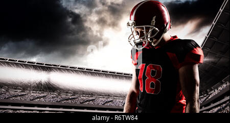 American football player im Helm gegen das zusammengesetzte Bild des Sports Arena mit Anhänger Stockfoto