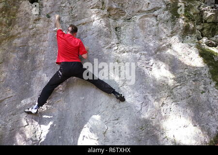 Sportler klettert auf Fels. Stockfoto