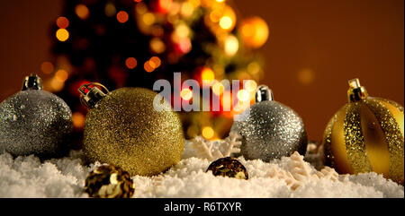 Weihnachten Kugeln liegen im Schnee gegen weissen Teppich gegen defokussiert Dekoration Stockfoto