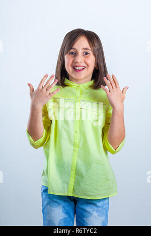 Kleines Mädchen im gelben Hemd für die Kamera posiert im Studio. Stockfoto