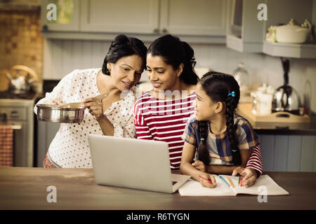 Multi-Generation, Familie mit Laptop in der Küche Stockfoto