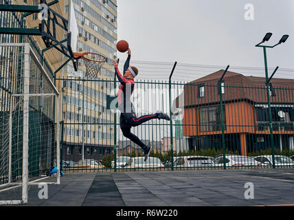 Basketball Spieler spielt auf der Straße Stockfoto