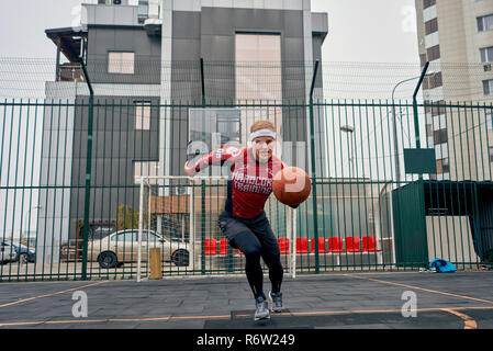 Basketball Spieler spielt auf der Straße Stockfoto