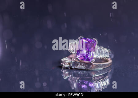 Verlobungsringe mit Wassertropfen auf dunklem Hintergrund Stockfoto