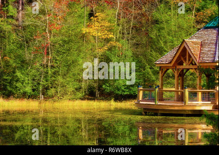 Bunte Herbst Farben reflektieren die Küste entlang, wo ein Pavillon in einer kleinen Bucht von Bay Mountain Lake Park in Kingsport Tennessee sitzt. Stockfoto