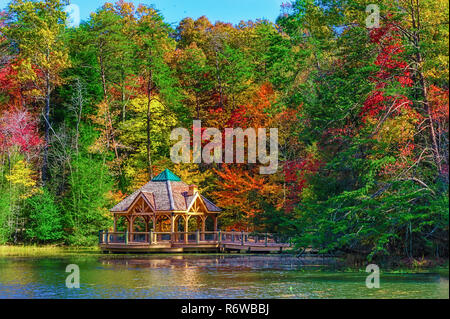 Bunte Herbst Farben reflektieren die Küste entlang, wo ein Pavillon in einer kleinen Bucht von Bay Mountain Lake Park in Kingsport Tennessee sitzt. Stockfoto