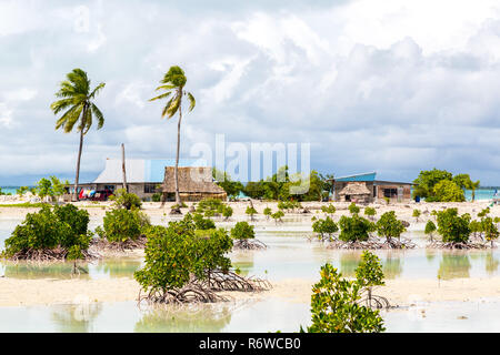 Dorf auf South Tarawa Atolls, Kiribati, Mikronesien, Ozeanien. Reetgedeckte Häuser. Das ländliche Leben auf einem sandigen Strand von fernen Paradies Insel unter Palmen. Stockfoto