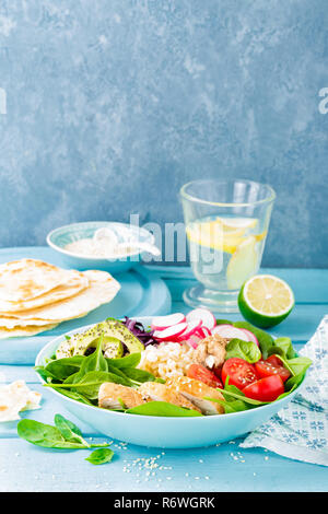 Schüssel mit gegrilltem Hähnchenfleisch, Bulgur und frisches Gemüse Salat, Radieschen, Tomaten, Avocado, Grünkohl und Spinat. Gesund und lecker Stockfoto