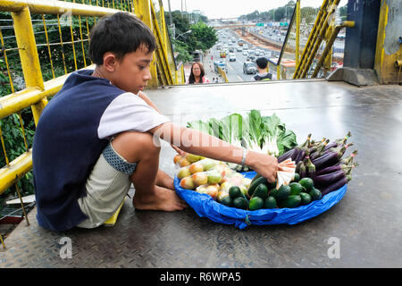 Kinderarbeit auf den Philippinen, junge Verkauf von Obst und Gemüse auf eine Überführung in Quezon City, Metro Manila, Philippinen Stockfoto