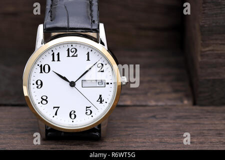 Armbanduhr mit Lederband auf hölzernen Hintergrund Stockfoto