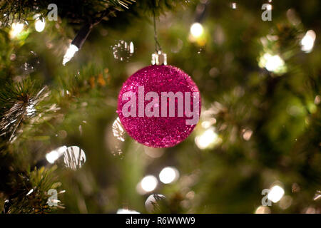 Pink Christmas Ornament am Baum mit Lichtern Stockfoto