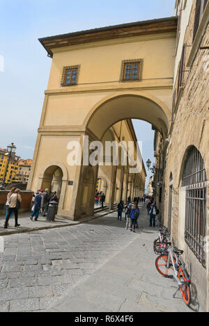 Vertikale Ansicht von Touristen zu Fuß unterhalb des Vasari Korridor in Florenz, Italien. Stockfoto