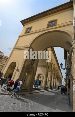 Vertikale Ansicht von Touristen zu Fuß unterhalb des Vasari Korridor in Florenz, Italien. Stockfoto
