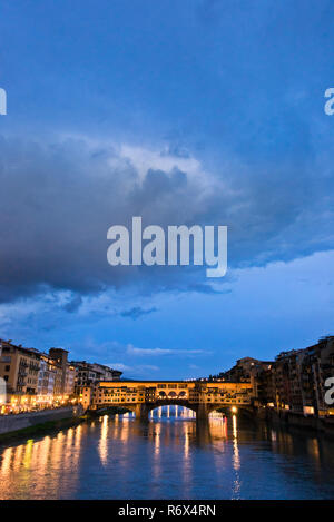 Vertikale Blick auf den Ponte Vecchio in der Nacht in Florenz, Italien, beleuchtet. Stockfoto