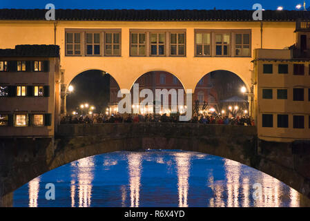 Horizontale Ansicht von Ponte Vecchio und Vasari Korridor bei Nacht in Florenz, Italien, beleuchtet. Stockfoto